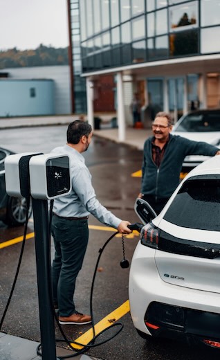 Technicien Pro Borne conseillant un client pro devant des bornes de recharge — expertise et accompagnement IRVE
